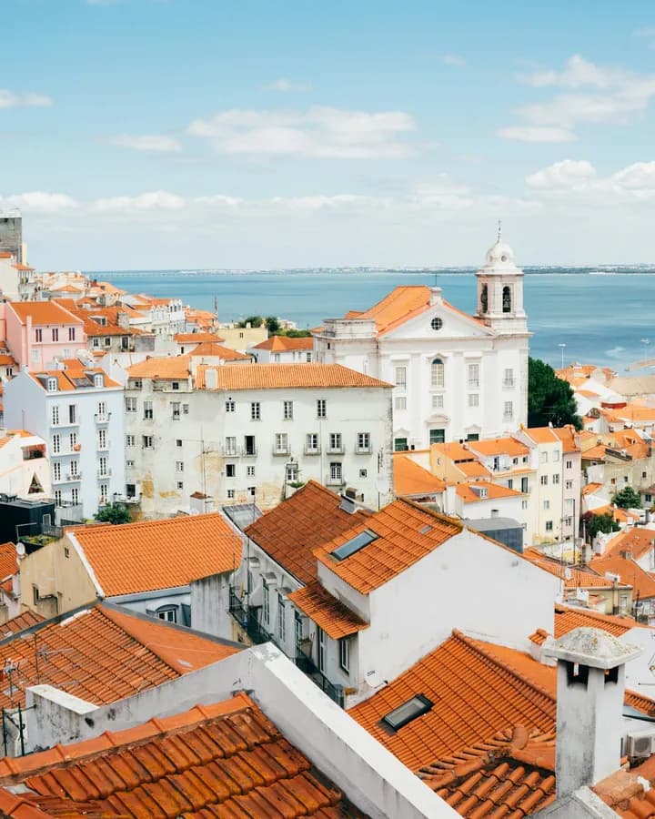 Terracotta rooftops of Lisbon by the river — call Portugal from $0.02 a minute with RobinPhone