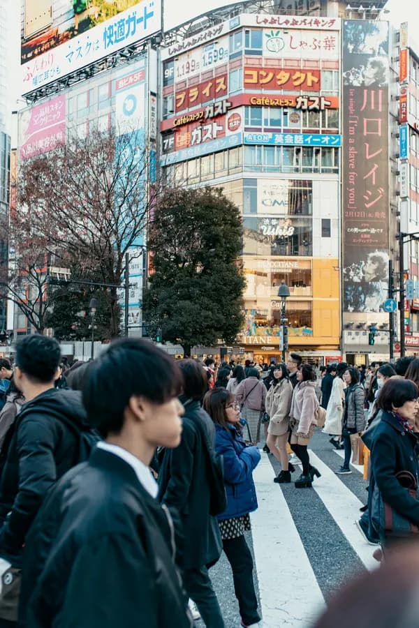People walking along a Tokyo sidewalk in daylight — call Japan from $0.04 a minute with RobinPhone